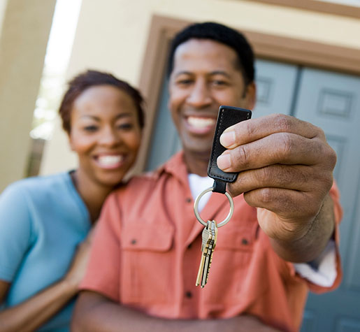 Happy African American couple showing a pair of keys of their new house