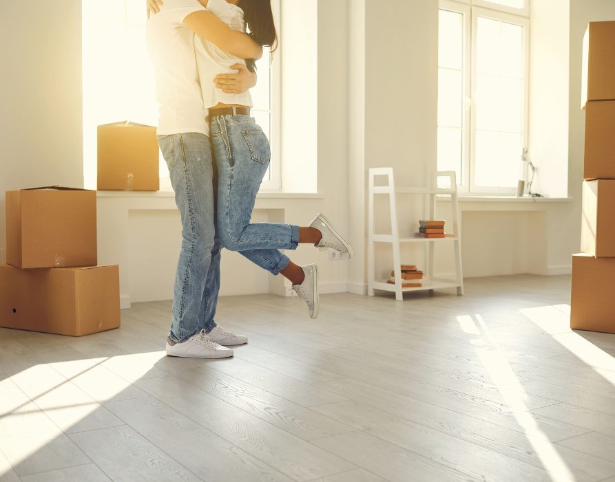 Happy Family Couple Hugs Dancing in a New Apartment